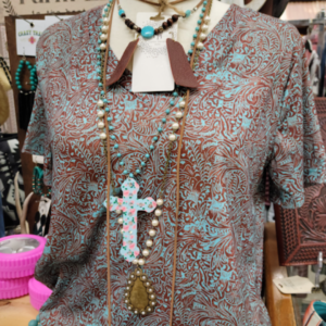 New Spring Arrivals: Patterned shirt and stack of turquise and cross necklaces