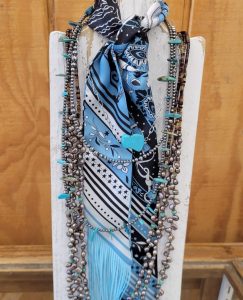 Blue and grey patterned scarf with necklaces